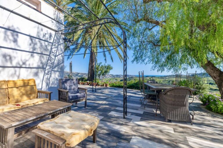 Terrace lounge at a traditional Spanish finca near Moraira with outdoor seating, pergola frame, countryside views and Mediterranean planting