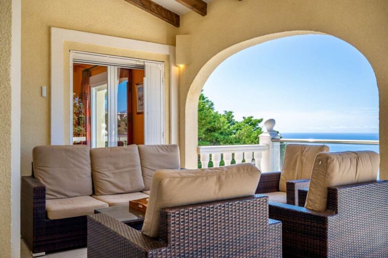 Terrace lounge at an elegant Mediterranean villa in Altea Hills with outdoor seating, arched opening and panoramic Mediterranean Sea views