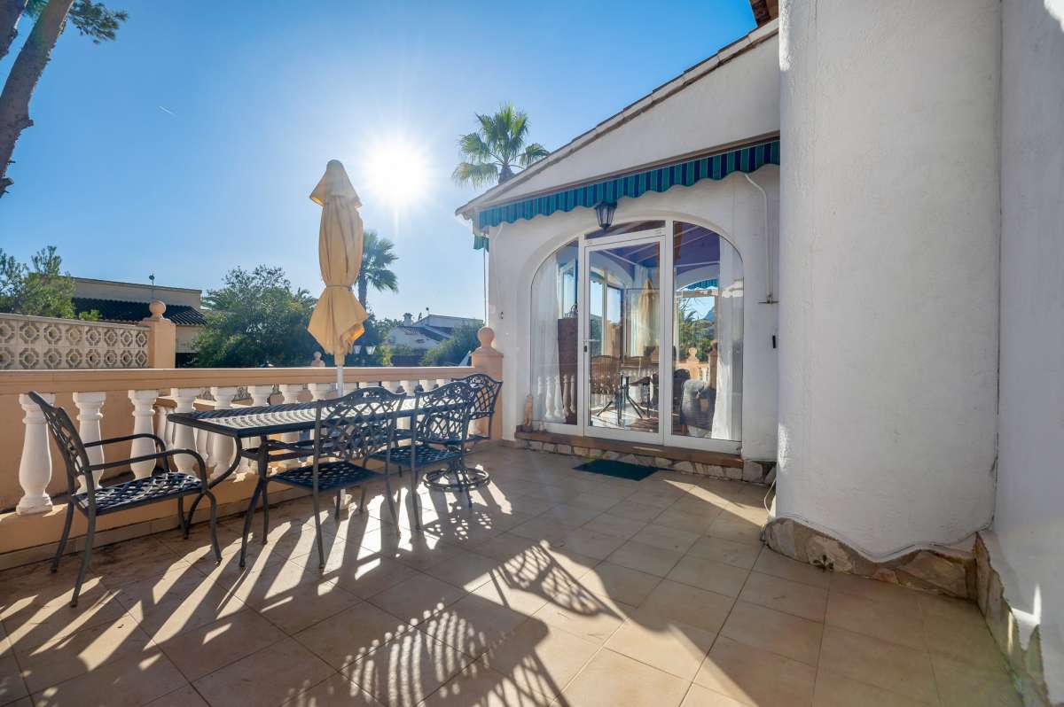 Terrace with outdoor seating beside the covered naya at a south-facing villa in Calpe close to amenities.