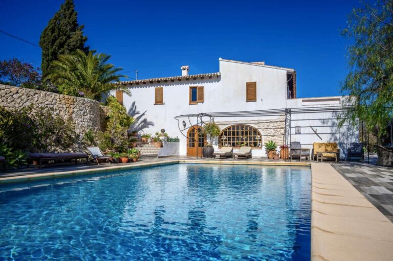 Traditional Spanish finca near Moraira with private swimming pool, white exterior, arched terrace, mature garden and rustic Mediterranean character