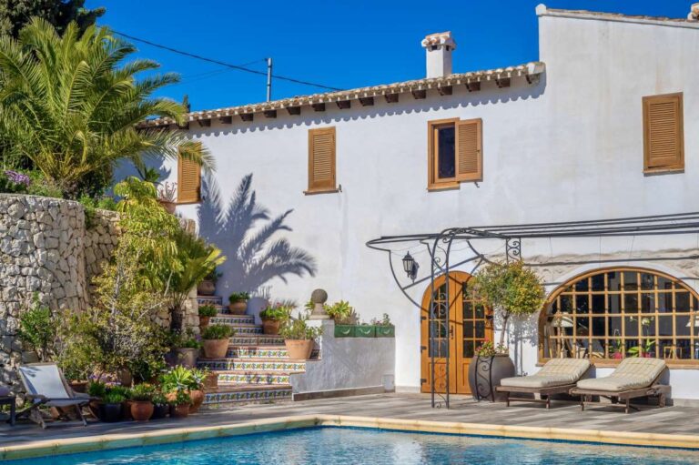 Traditional Spanish finca near Moraira with private swimming pool, white façade, arched terrace, sun loungers and rustic Mediterranean character