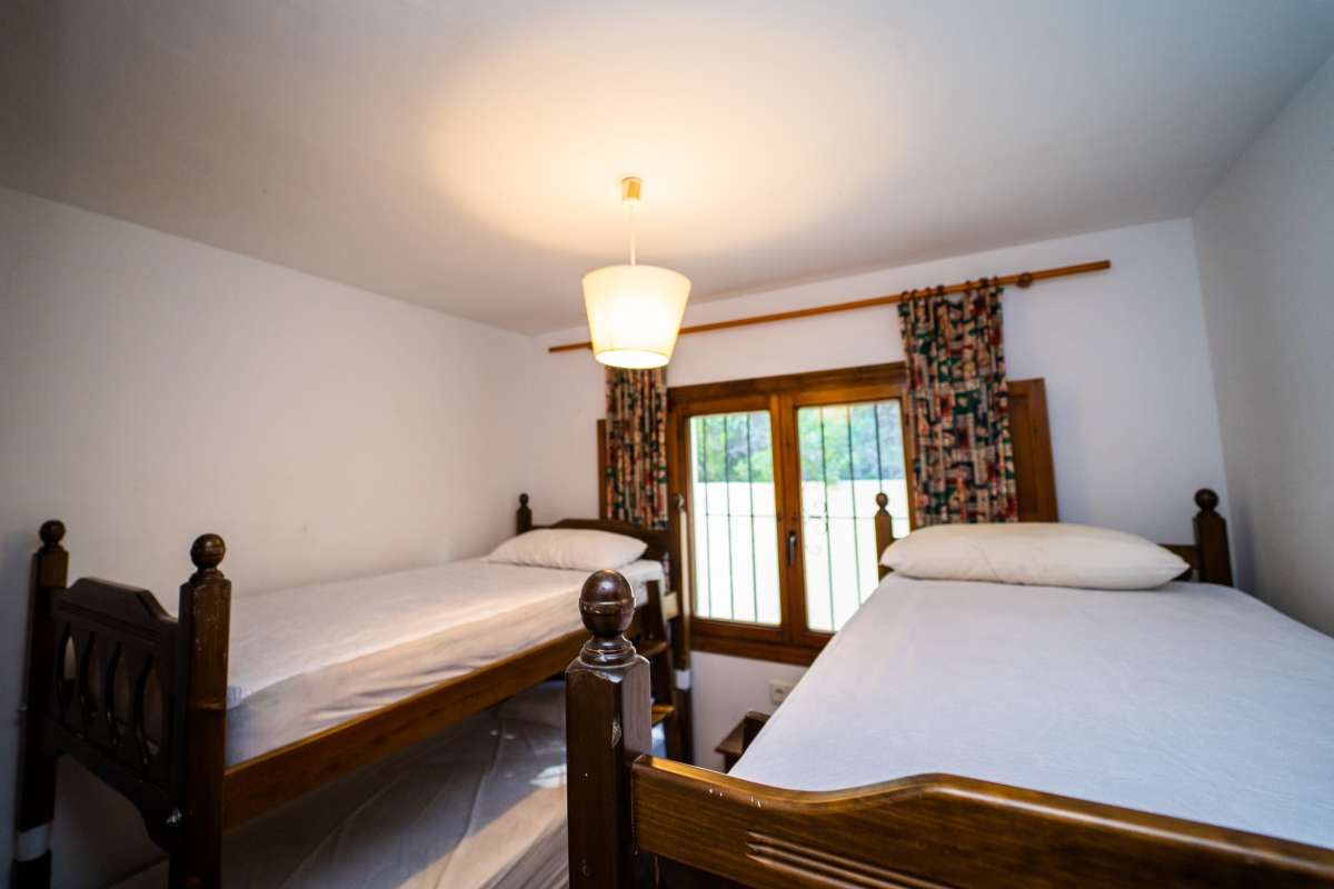 Twin bedroom detail with traditional wooden beds and natural light inside a Mediterranean villa in Calpe.