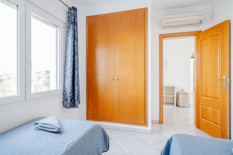 Twin bedroom in a Calpe villa with built-in wardrobe, large window and en-suite bathroom access
