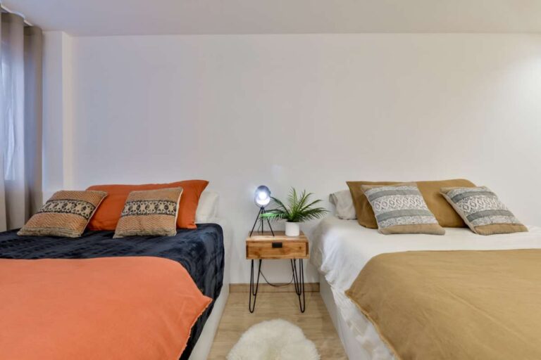 Twin bedroom inside a luxury frontline beach duplex in Mascarat, Altea with two beds, bedside table, soft lighting and modern interior finish