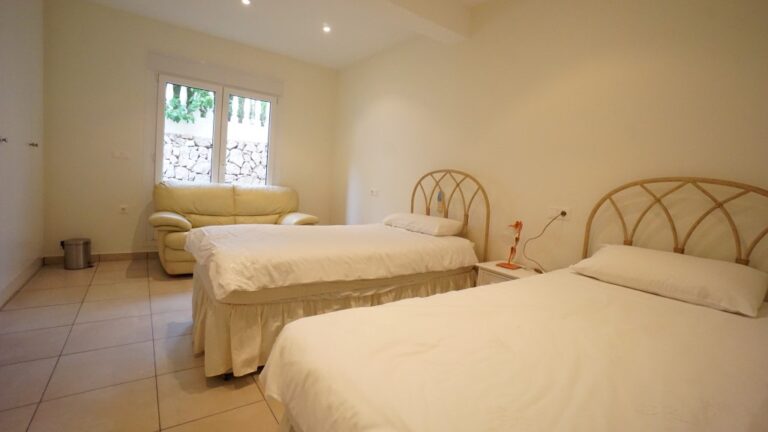 Twin bedroom with natural light inside a villa in La Fustera, close to the sea.