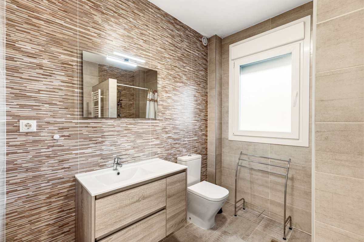 Upper floor bathroom with vanity, window and modern tile detailing inside a contemporary villa in Calpe.