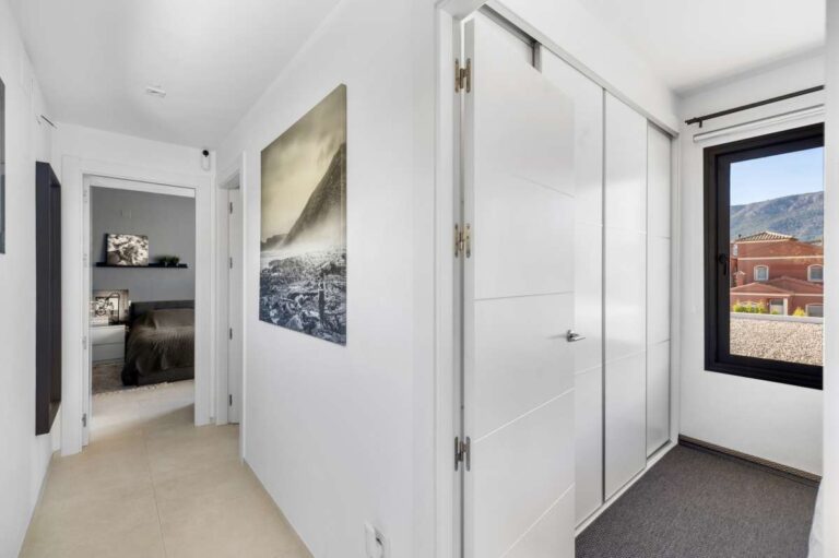 Upper floor hallway with fitted wardrobes and natural light inside a modern oasis villa for sale in Calpe.