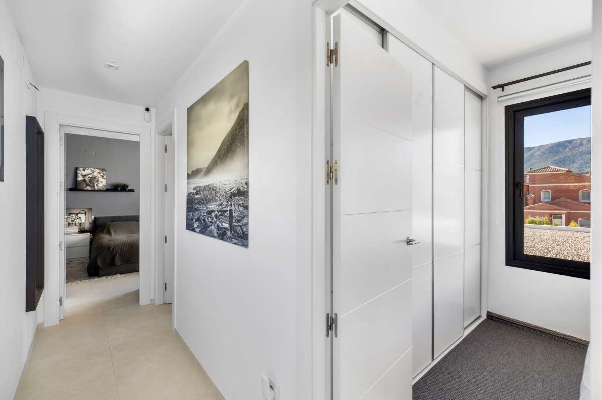 Upper floor hallway with fitted wardrobes and natural light inside a modern oasis villa for sale in Calpe.