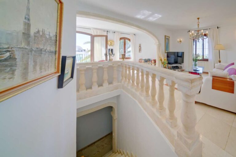 Upper floor landing with balustrade and bright living area inside a second line Mediterranean villa in Calpe.