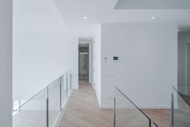 Upper hallway inside a modern villa in La Calalga, Calpe with glass balustrade, wood flooring and bright contemporary interior