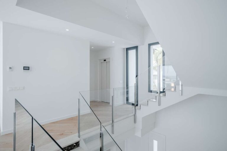 Upper landing inside a modern second-line sea villa in La Calalga, Calpe with glass balustrade, bright interior and contemporary finish
