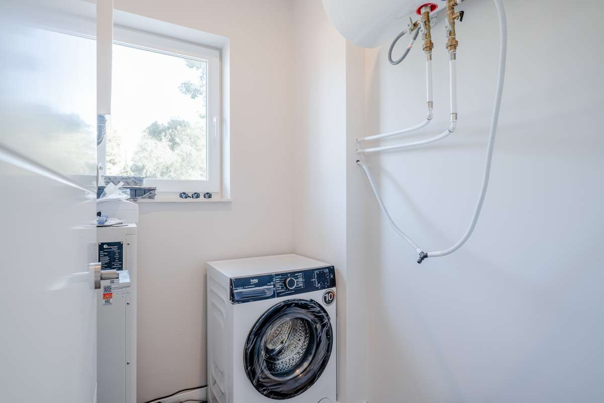 Utility room with washing machine and water heater inside a new build villa in Calpe