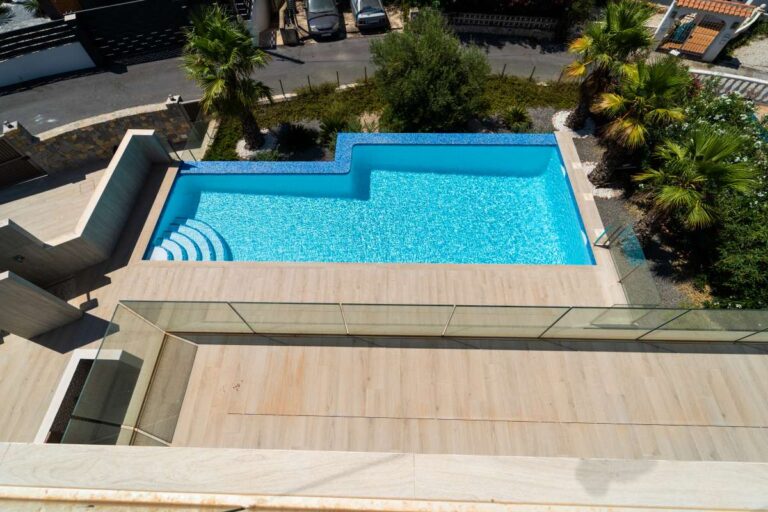 Blick auf den privaten Swimmingpool von einer neu erbauten Luxusvilla in der Nähe des Yachthafens Puerto Blanco in Calpe mit Terrasse und gepflegter Gartenanlage