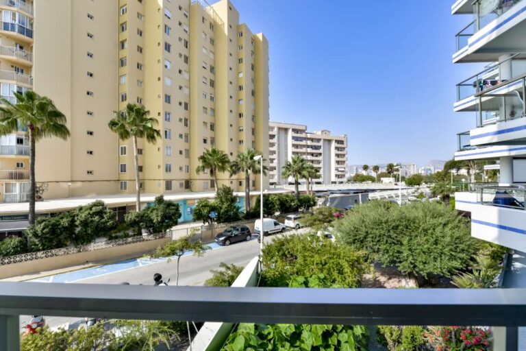 Views from the terrace of a frontline La Fossa apartment in Calpe with nearby buildings, palm trees and beach access