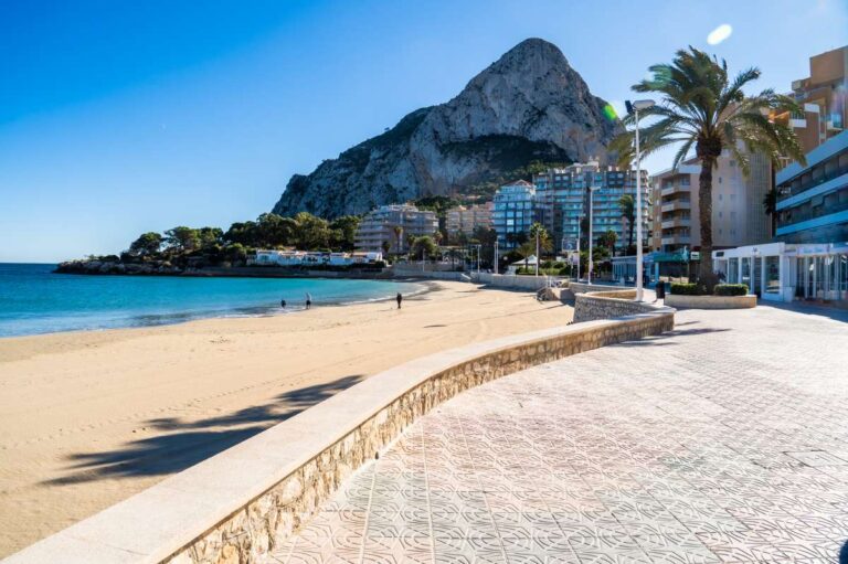 Views of La Fossa Beach in Calpe with the seafront promenade, sandy beach, Mediterranean Sea and Peñón de Ifach
