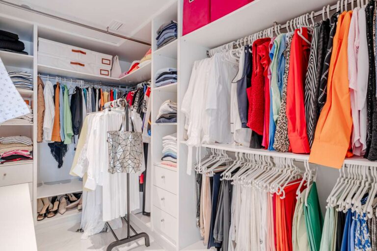 Walk-in dressing room inside a renovated apartment by Arenal-Bol Beach in Calpe with fitted shelving and hanging storage