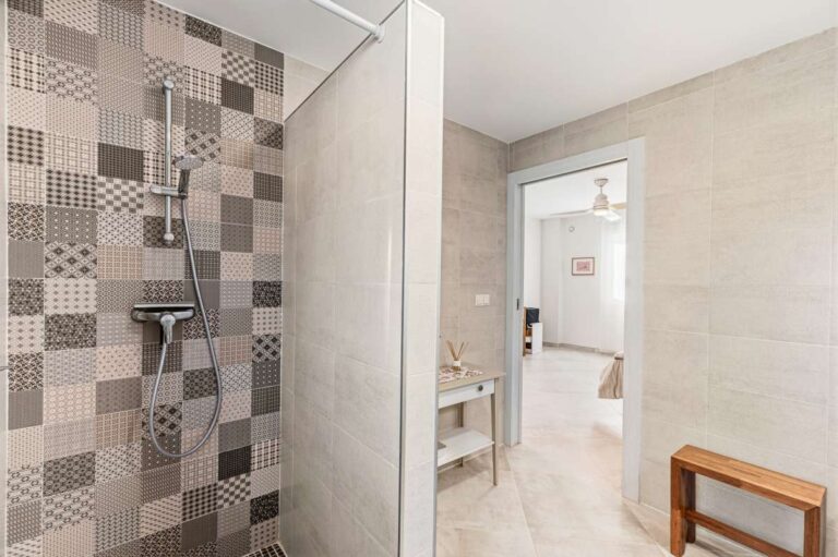 Walk-in shower with patterned tile detailing inside a modern bathroom in a contemporary villa in Calpe.