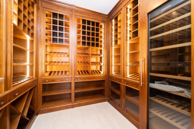 Wooden wine cellar inside a luxury villa in Calpe with built-in wine storage, glass-fronted display and warm lighting
