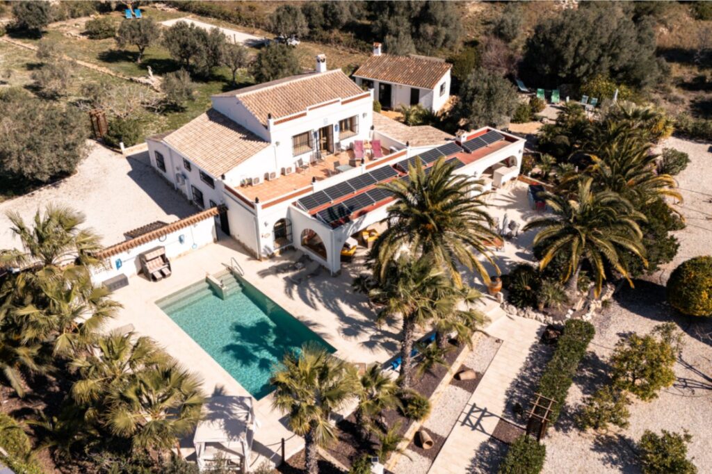 Aerial view of a renovated finca near Teulada and Moraira with private swimming pool, palm trees, terraces and landscaped Mediterranean gardens