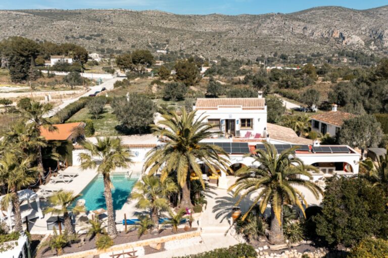 Aerial view of a renovated finca near Teulada and Moraira with swimming pool, palm trees, countryside views and private garden setting