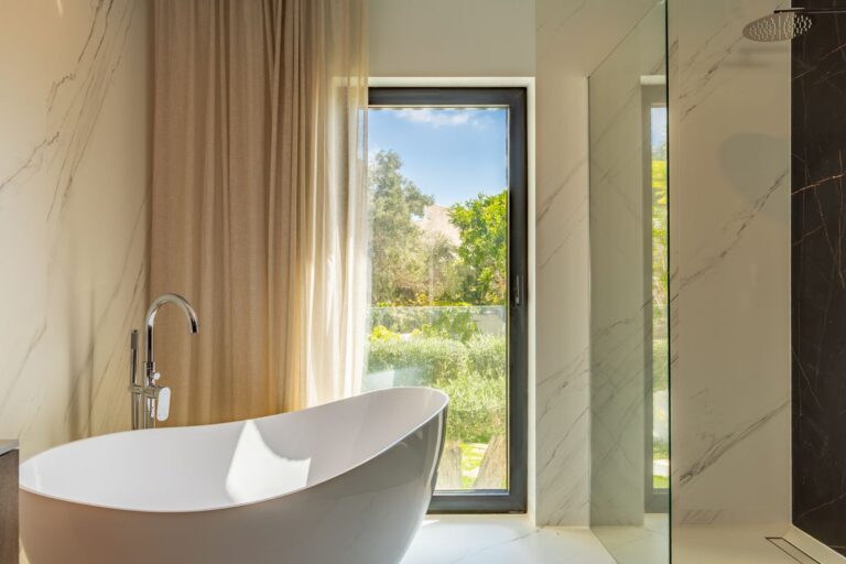 Bathroom inside a luxury smart home villa near Moraira with freestanding bath, garden views, walk-in shower and floor-to-ceiling window