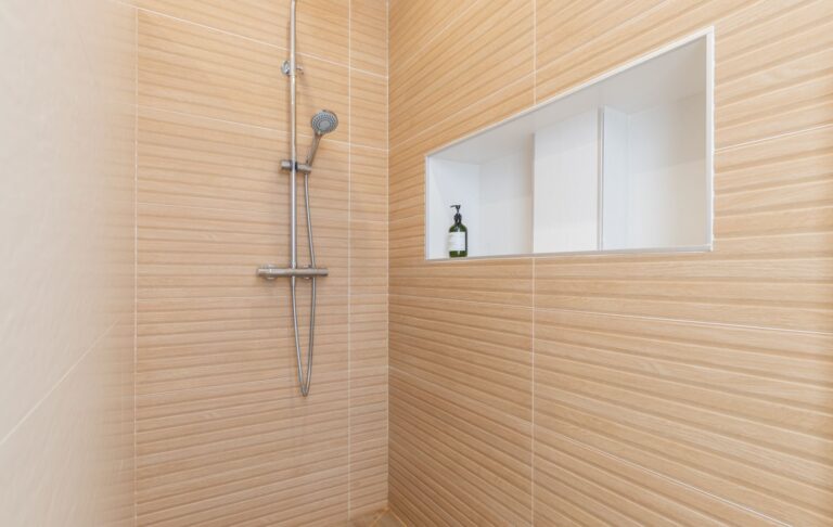 Bathroom inside a modern villa in Pla del Mar, Moraira with walk-in shower, beige wall tiles, recessed shelf and contemporary finish