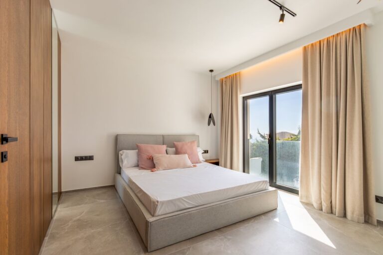 Bedroom inside a luxury smart home villa near Moraira with terrace access, large sliding doors, fitted wardrobe, neutral finishes and natural light