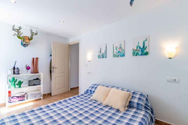 Bedroom inside a Mediterranean villa near Cala Baladrar in Benissa Costa with double bed, coastal decor, wall lighting and bright white interior