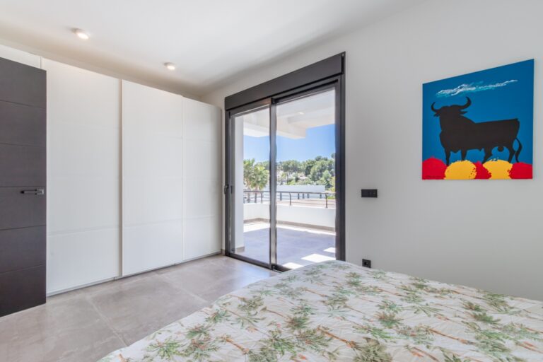 Bedroom inside a modern villa in Solpark, Moraira with fitted wardrobes, private terrace access, double bed and bright contemporary finish