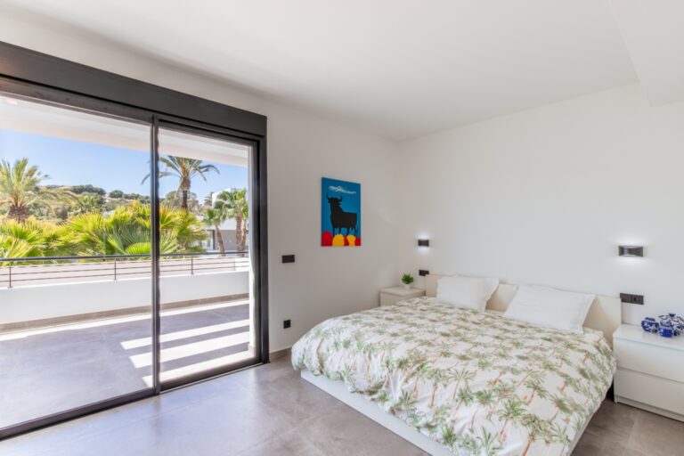 Bedroom inside a modern villa in Solpark, Moraira with private terrace access, large sliding doors, double bed and bright neutral interior