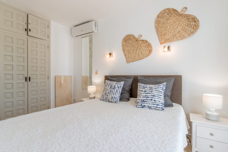 Bedroom inside a renovated Mediterranean villa in Moraira with fitted wardrobes, air conditioning, double bed and bright neutral finish