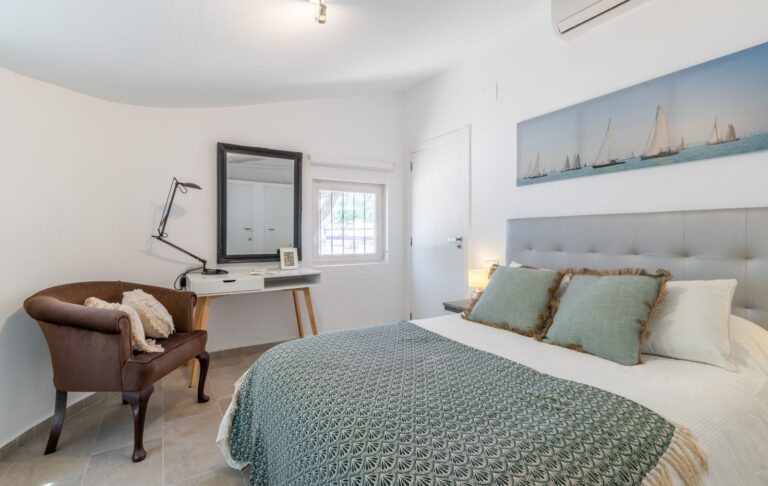 Bedroom inside a renovated Mediterranean villa near Cala Baladrar in Benissa Costa with desk area, double bed, bright window and air conditioning