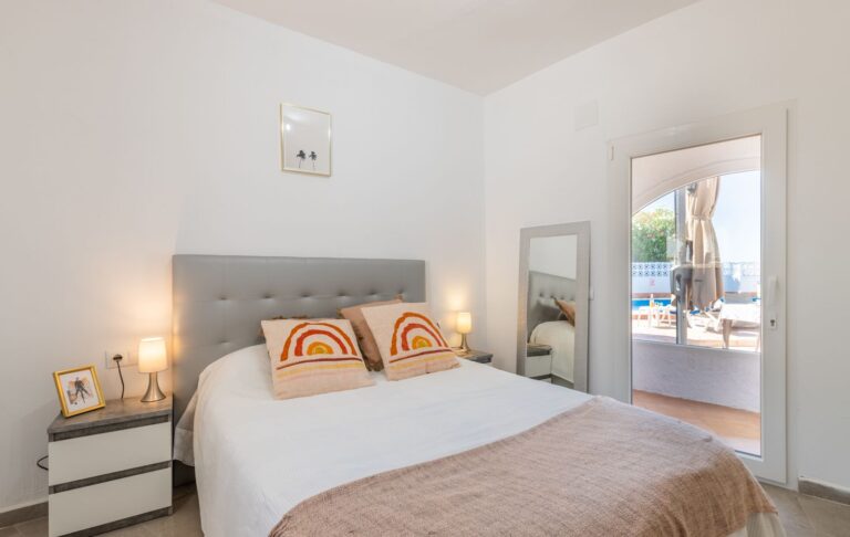 Bedroom inside a renovated Mediterranean villa near Cala Baladrar in Benissa Costa with double bed, pool terrace access and bright neutral interior