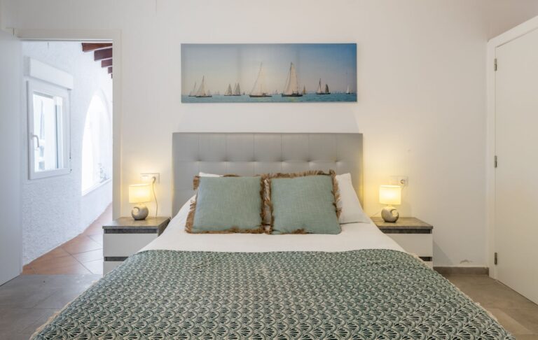 Bedroom inside a renovated villa near Cala Baladrar in Benissa Costa with double bed, bedside lighting, bright window and modern neutral finish