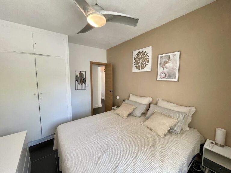 Bedroom with built-in wardrobes and ceiling fan in a villa for sale in Calpe