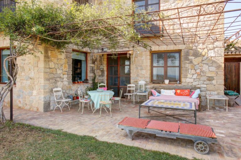 Courtyard terrace at a rustic Mediterranean estate near Moraira with natural stone exterior, outdoor seating, pergola and traditional Mediterranean character