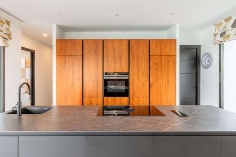 DEKTON kitchen island inside a modern villa in Solpark, Moraira with BORA induction hob, wooden cabinetry, integrated appliances and premium finish