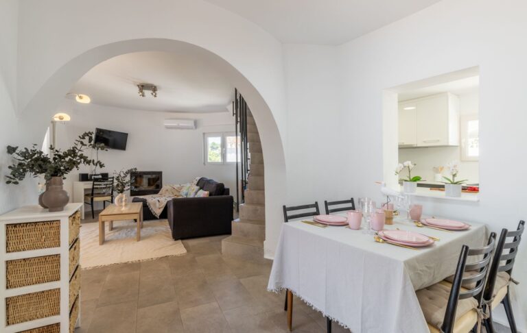 Dining area inside a renovated Mediterranean villa near Cala Baladrar in Benissa Costa with arched opening, living room access and bright interior
