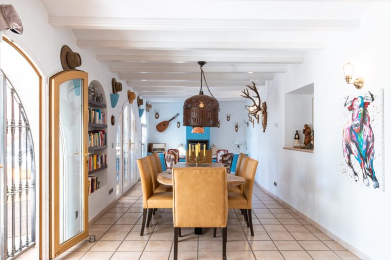 Dining room inside a renovated finca near Teulada and Moraira with wooden dining table, white beamed ceiling, garden access and bright traditional interior