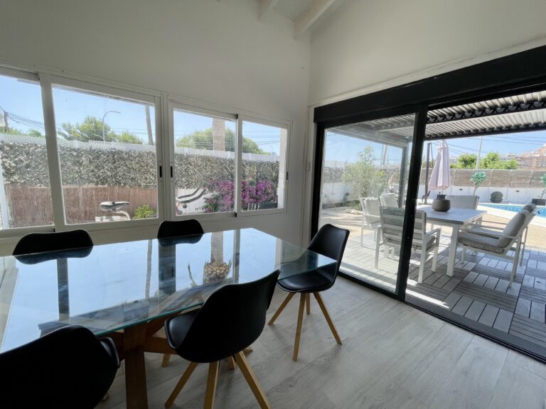 Dining room with glass doors overlooking the pool terrace at a villa in Calpe