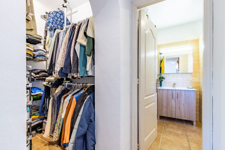 Dressing area inside a Mediterranean villa near Cala Baladrar in Benissa Costa with open wardrobe storage, bathroom access and practical layout