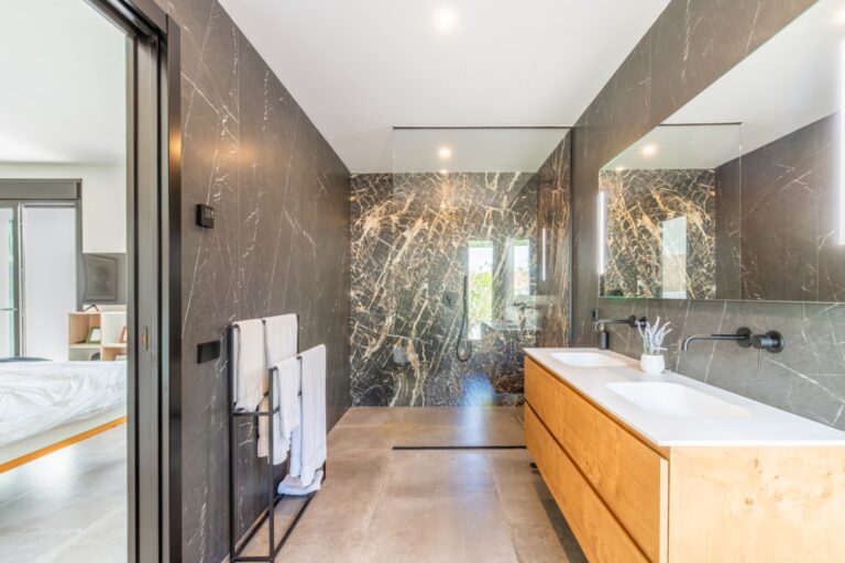 En-suite bathroom inside a modern villa in Solpark, Moraira with double vanity, walk-in shower, dark wall tiles and premium contemporary finish