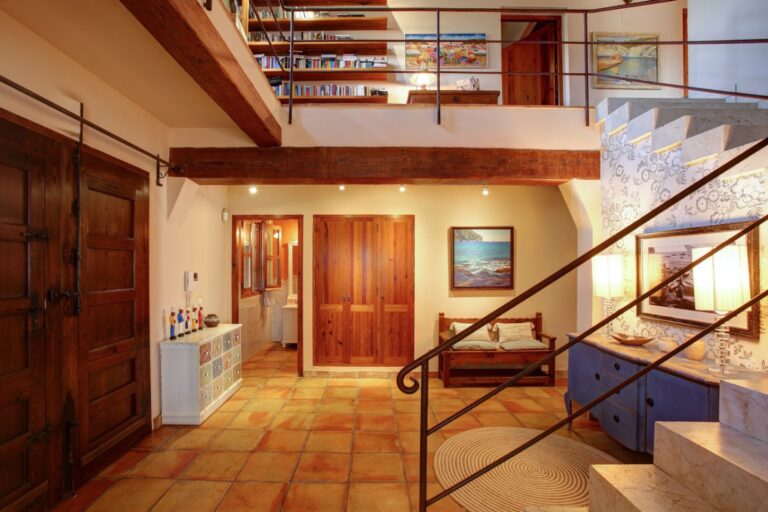 Entrance hall inside a rustic Mediterranean estate near Moraira with terracotta flooring, wooden doors, marble staircase and traditional interior details