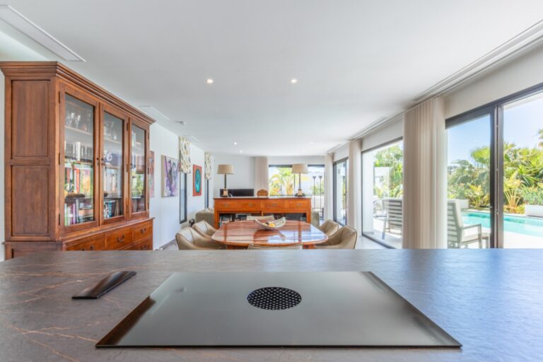 Kitchen inside a modern villa in Solpark, Moraira with island, integrated hob, open-plan living area, pool views and bright contemporary design