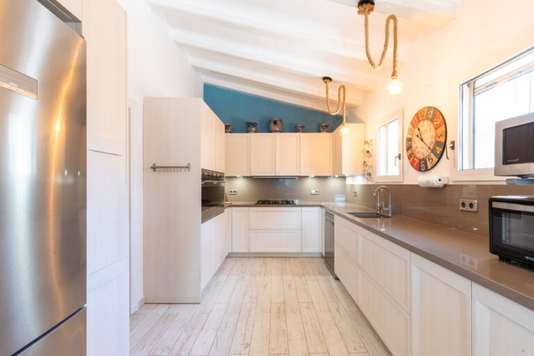 Kitchen inside a renovated finca near Teulada and Moraira with fitted cabinetry, modern appliances, bright windows and practical worktop space
