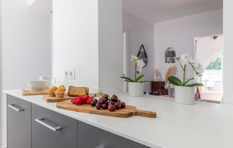 Kitchen worktop inside a renovated villa near Cala Baladrar in Benissa Costa with fruit display, grey cabinetry, white finish and bright modern design