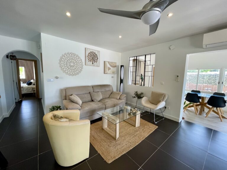 Living room and dining area with large glass doors in a villa in Calpe