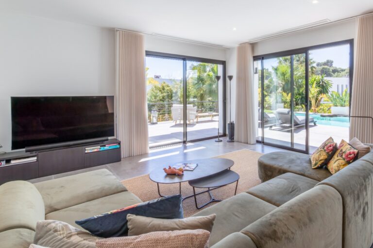 Living room inside a modern villa in Solpark, Moraira with sofa seating, large sliding doors, pool terrace access and bright contemporary interior