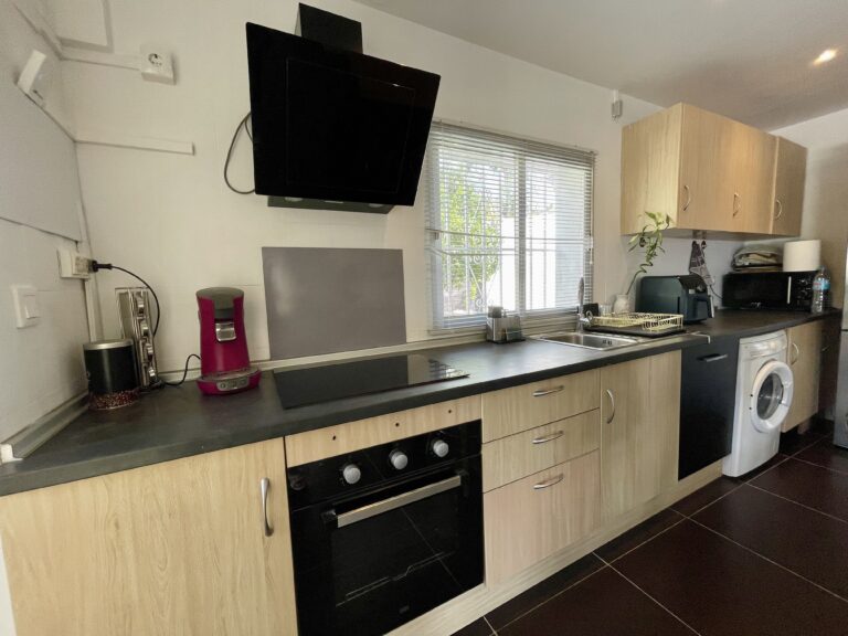 Modern equipped kitchen with workspace and storage in a villa for sale in Calpe