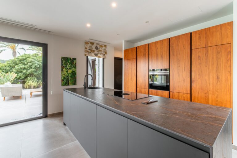 Modern kitchen inside a luxury villa in Solpark, Moraira with DEKTON island, wooden cabinetry, premium appliances and terrace access